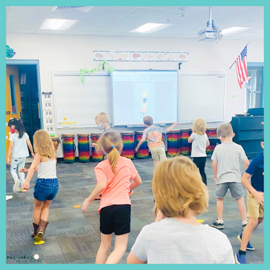 Kindergarteners pretending to roller skate  with the Spring Music and Movement Cards on the Smart Board spring-movement-activities-for-music-class